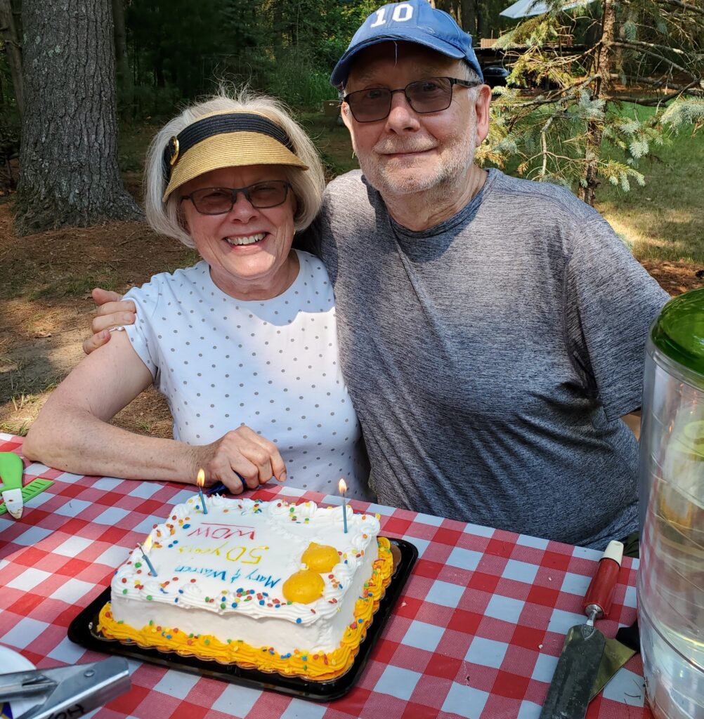 Couple smiles at a picnic celebrating their 50th wedding anniversary
