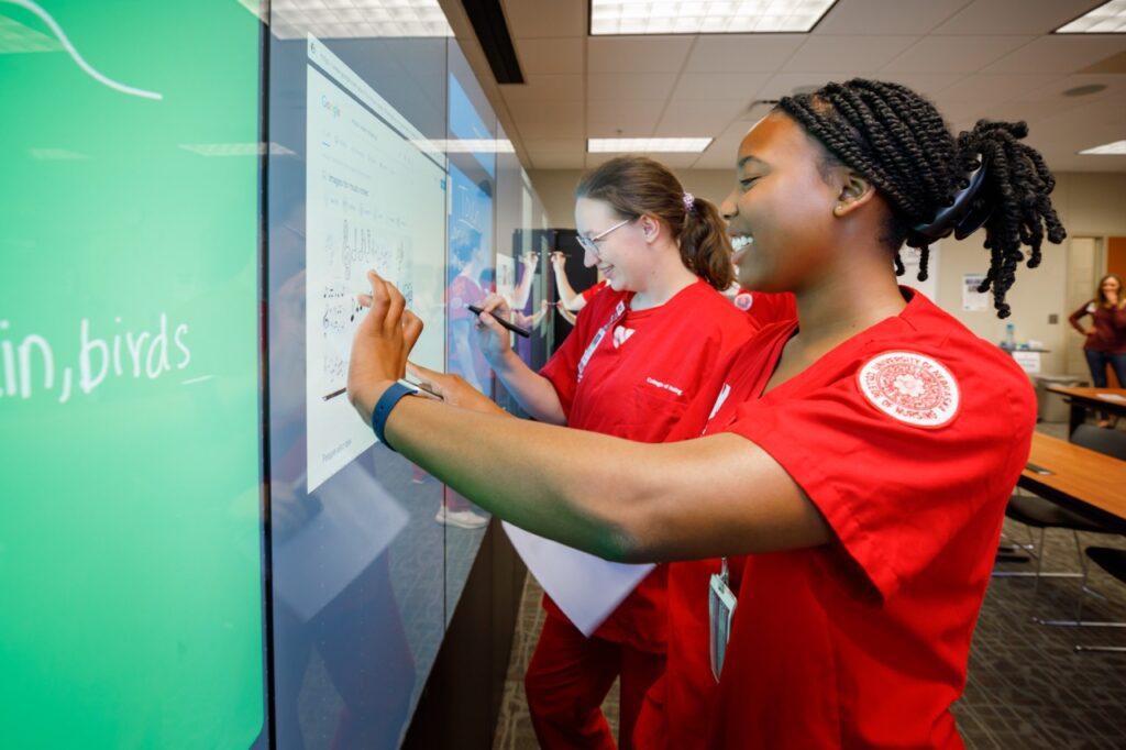 Nursing students work together on video board