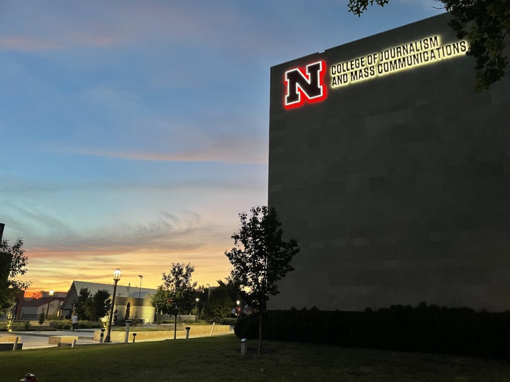 UNL College of Journalism and Mass Communications with sun setting in the background.